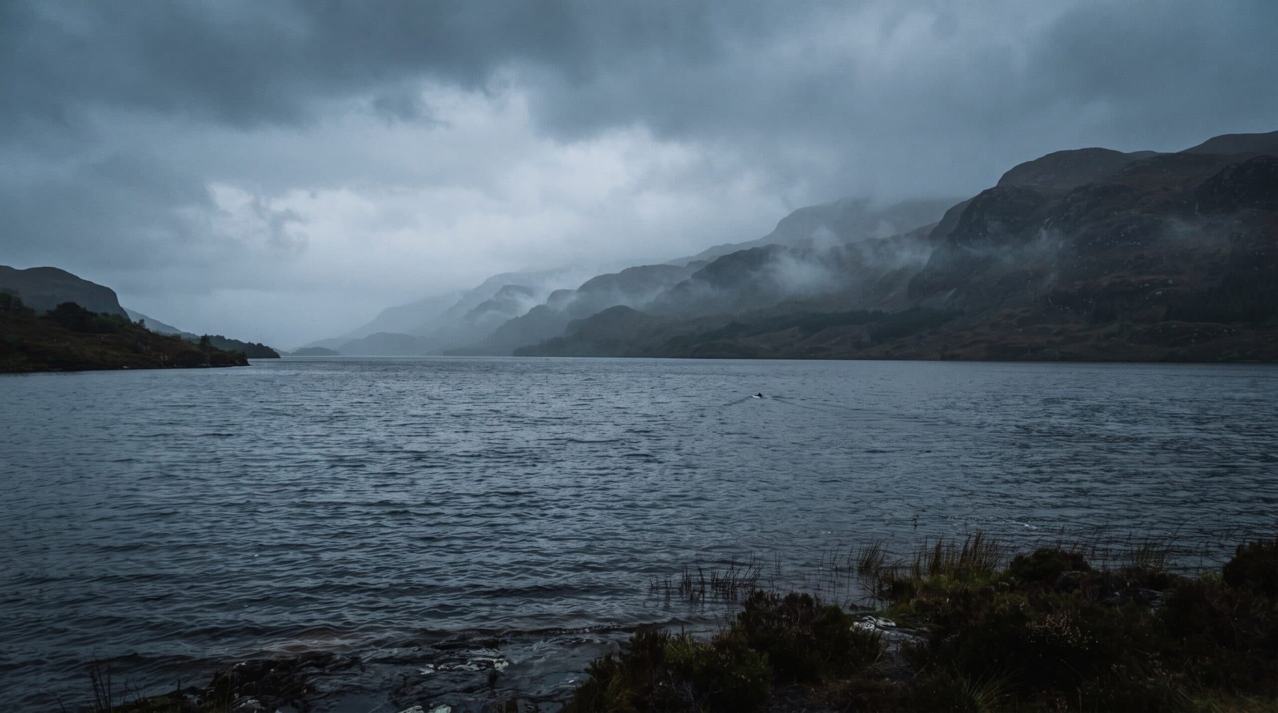 Misty Loch Ness with an ambiguous disturbance on the distant water